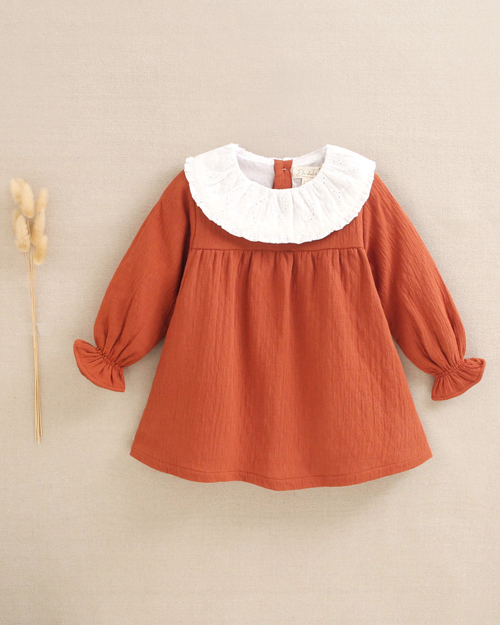 Vestido de bebé niñacolor teja y manga larga abullonada