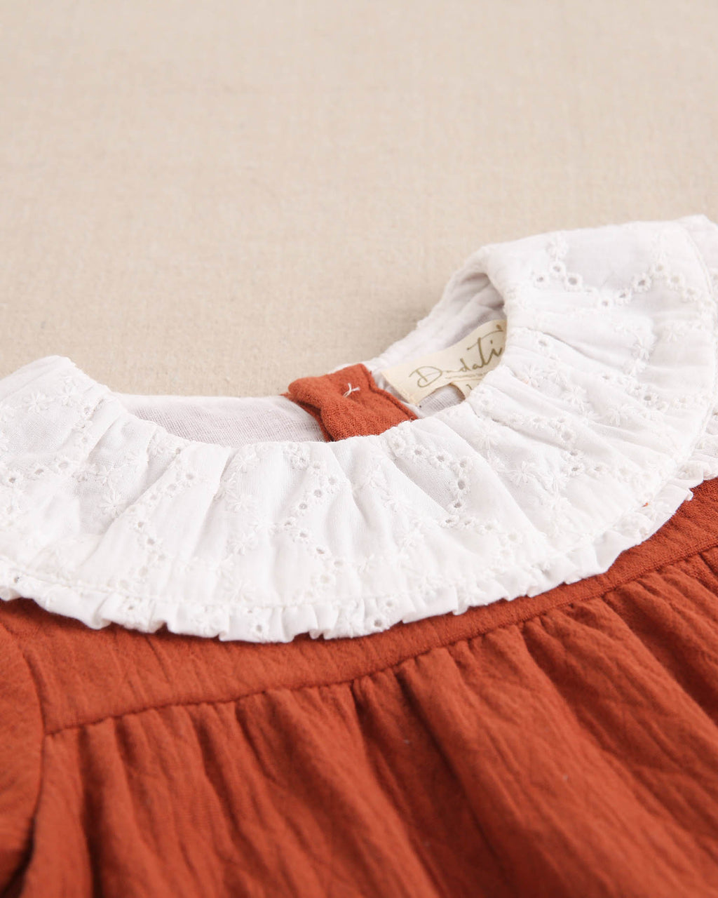Vestido de bebé niñacolor teja y manga larga abullonada