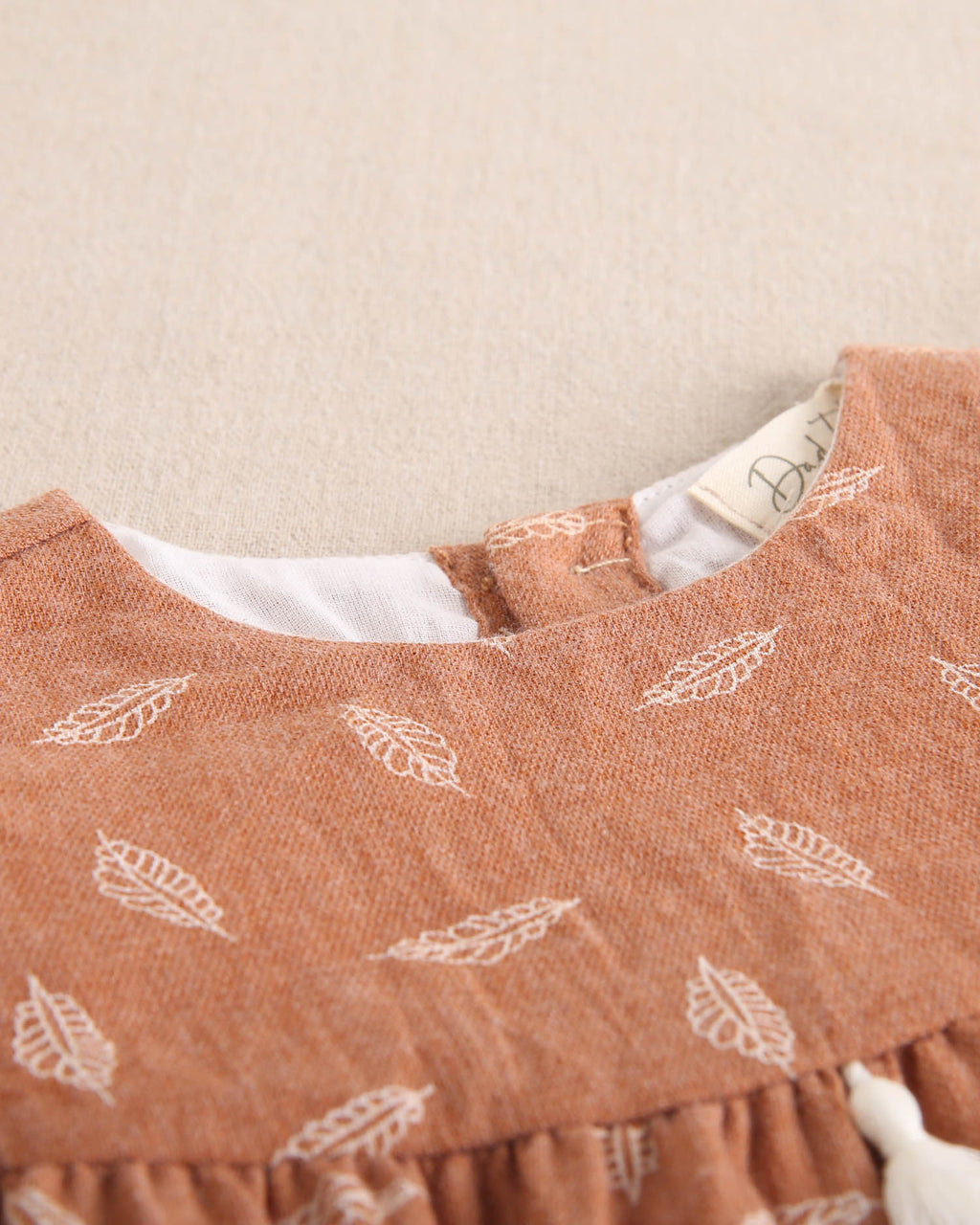 Ranita de bebé niña teja con estampado y detalle de borla