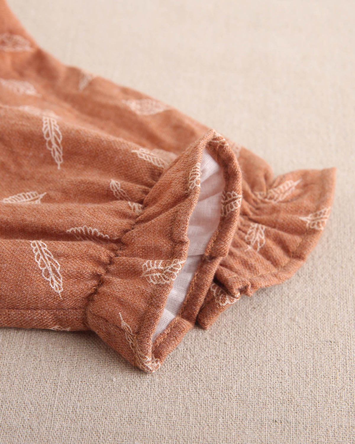 Ranita de bebé niña teja con estampado y detalle de borla