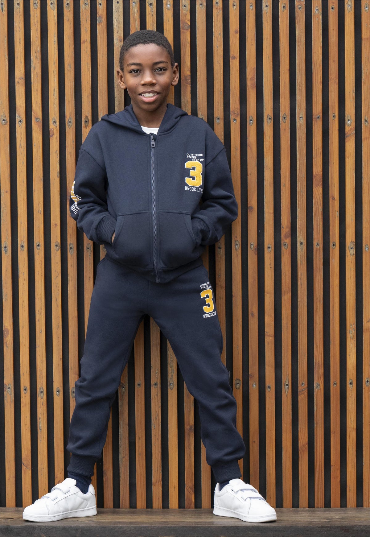 Niño con conjunto chándal Brooklyn Nº3 azul marino con estampados en amarillo mostaza