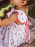 Vestido blanco con detalles rojos y lazada en espalda