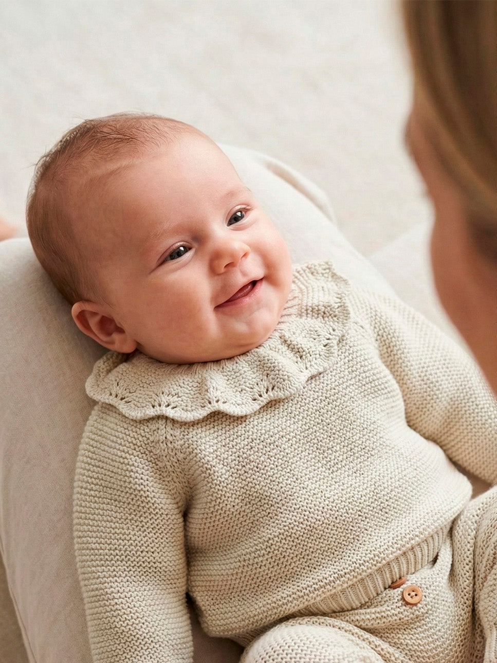 Bebé con conjunto de punto gris cuello volante y polaina