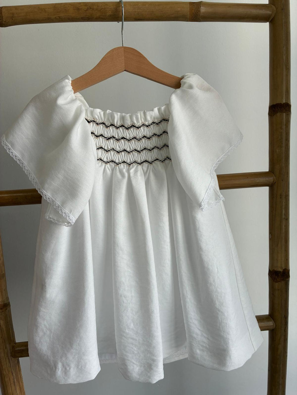 Vestido blanco con mangas de volantes y tejido central punto smock