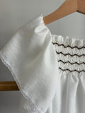 Vestido blanco con mangas de volantes y tejido central punto smock