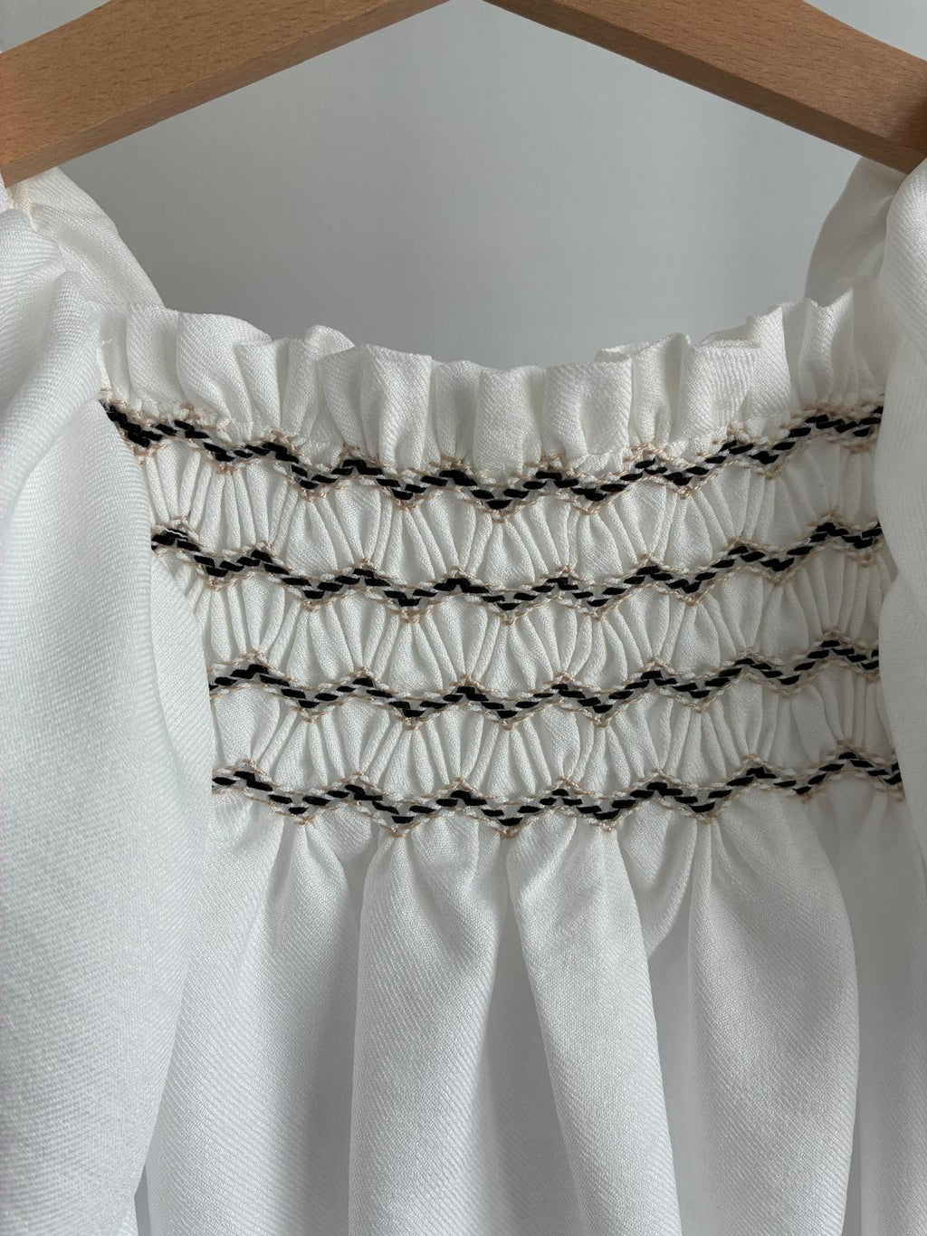 Vestido blanco con mangas de volantes y tejido central punto smock